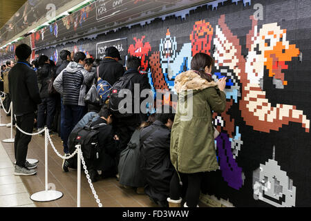 Dragon Quest fans collect blocks from a giant Lego wall mural on January 28, 2016 in Tokyo, Japan. The mural is part of a promotion in Shinjuku Station to celebrate the release of new game Dragon Quest Builders. The 80 meter mural was made with 180,000 Lego blocks and fans were allowed to remove blocks to reveal a secret poster behind. Some blocks contained QR codes allowing fans to access exclusive content. © Rodrigo Reyes Marin/AFLO/Alamy Live News Stock Photo