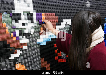 Dragon Quest fans collect blocks from a giant Lego wall mural on January 28, 2016 in Tokyo, Japan. The mural is part of a promotion in Shinjuku Station to celebrate the release of new game Dragon Quest Builders. The 80 meter mural was made with 180,000 Lego blocks and fans were allowed to remove blocks to reveal a secret poster behind. Some blocks contained QR codes allowing fans to access exclusive content. © Rodrigo Reyes Marin/AFLO/Alamy Live News Stock Photo