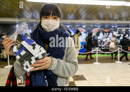 Dragon Quest fans collect blocks from a giant Lego wall mural on January 28, 2016 in Tokyo, Japan. The mural is part of a promotion in Shinjuku Station to celebrate the release of new game Dragon Quest Builders. The 80 meter mural was made with 180,000 Lego blocks and fans were allowed to remove blocks to reveal a secret poster behind. Some blocks contained QR codes allowing fans to access exclusive content. © Rodrigo Reyes Marin/AFLO/Alamy Live News Stock Photo