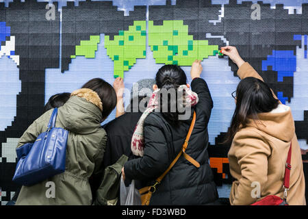 Dragon Quest fans collect blocks from a giant Lego wall mural on January 28, 2016 in Tokyo, Japan. The mural is part of a promotion in Shinjuku Station to celebrate the release of new game Dragon Quest Builders. The 80 meter mural was made with 180,000 Lego blocks and fans were allowed to remove blocks to reveal a secret poster behind. Some blocks contained QR codes allowing fans to access exclusive content. © Rodrigo Reyes Marin/AFLO/Alamy Live News Stock Photo