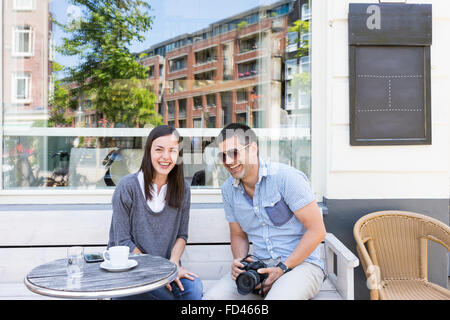 Friends coffee morning on a terrace in the center of Amsterdam laughing heartily Stock Photo