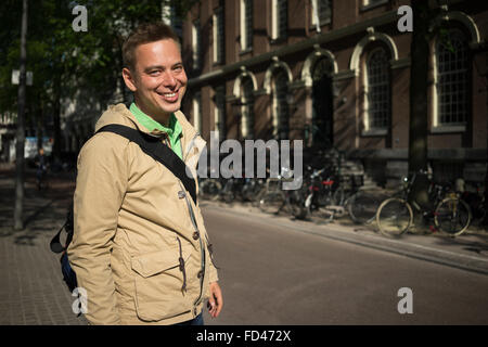 Handsome blond young man with green eyes smiling Travelling in Europe Stock Photo