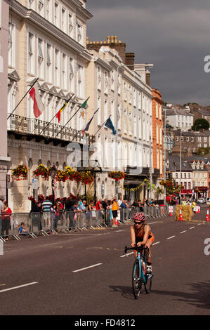 Female triathlete starts the bike section under a dramatic sky  in Cobh Triathlon, Cobh, County Cork, Ireland. Stock Photo