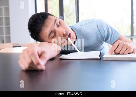 College student falling asleep in library Stock Photo