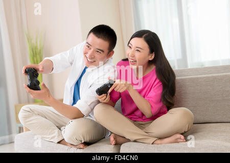 Chinese Boyfriend And Girlfriend Playing Video Games Sitting At