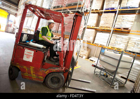 a man working on a fork lift truck in a warehouse Stock Photo