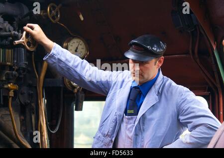 Engineer adjusting valve of steam train LMS Princess Coronation Class 46233 Duchess of Sutherland. Stock Photo