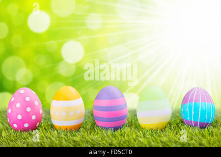 A collection of colourful hand-painted Easter eggs lying in the grass. Stock Photo