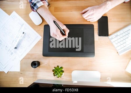 Top view of table of graphic designer using black pen tablet with stylus Stock Photo