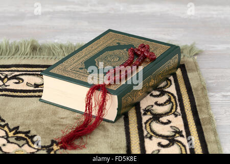 Koran book and the prayer beads on a carpet Stock Photo