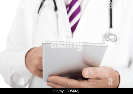 Close up of the hands of a male doctor in a lab coat and stethoscope working on a tablet -pc entering patient records, or access Stock Photo