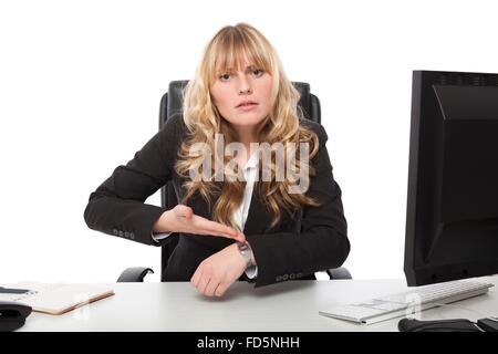 Businesswoman pointing at her wrist watch with her hand and an intense look on her face as she tries to explain something Stock Photo