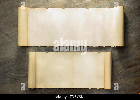parchment scroll on stone wall background Stock Photo