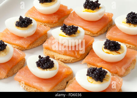Snack with salmon,quail eggs and lumpfish roe on toast Stock Photo
