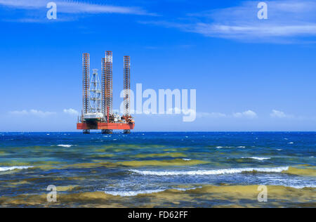 Offshore oil rig drilling platform in the sea against blue sky Stock Photo