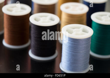 Several sewing thread spools neatly displayed with a shallow depth of field. Stock Photo