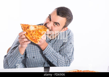 Young man biting a piece of vegetarian pizza Stock Photo