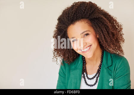 Mixed race businesswoman with a curly afro smiling warmly Stock Photo