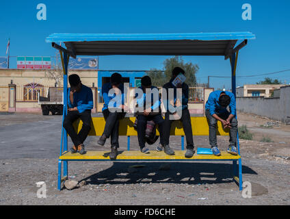 schoolboys waiting for the bus, Hormozgan, Bandar-e Kong, Iran Stock Photo