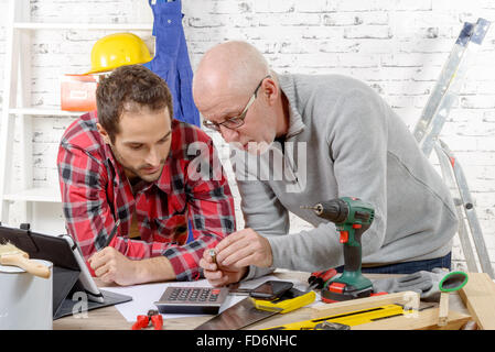 two technician examining a mechanical part in the workshop Stock Photo
