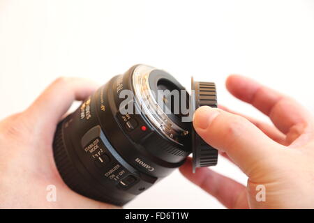 Hand moving lens cap on a white background Stock Photo