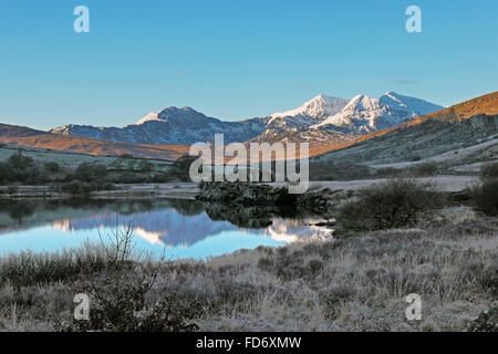 Snowdon on a bright frosty morning in January viewed from the A4086 1 mile west of Capel Curig 7 miles east of Snowdon peak and rocks by Llynnau Mymby Stock Photo