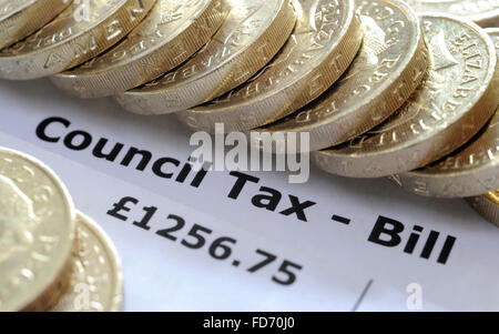 COUNCIL TAX BILL WITH ONE POUND COINS RE HOUSEHOLD INCOMES BILLS BUDGET WAGES GOVERNMENT HOUSE TAX BANDS HOMES WAGES HOUSING UK Stock Photo