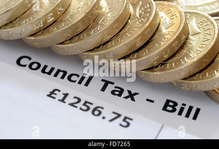 COUNCIL TAX BILL WITH ONE POUND COINS RE HOUSEHOLD INCOMES BILLS BUDGET WAGES GOVERNMENT HOUSE TAX BANDS HOMES WAGES HOUSING UK Stock Photo