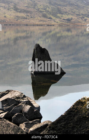 Rock reflection in lake Llynnau Mymbyr in Dyffryn Mymbyr, a valley running from the village of Capel Curig Snowdonia Wales Stock Photo