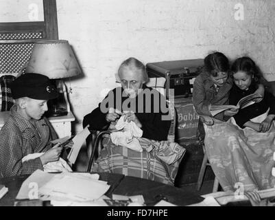 Kids with their grandmother in a bomb shelter, Berlin 1940 Stock Photo