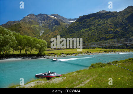 Jet boats and people on suspension bridge over Matukituki River West Branch, Matukituki Valley, near Wanaka, Otago, South Island Stock Photo