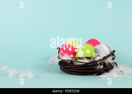 Bright Colorful Easter Eggs in Nest with Feathers Stock Photo