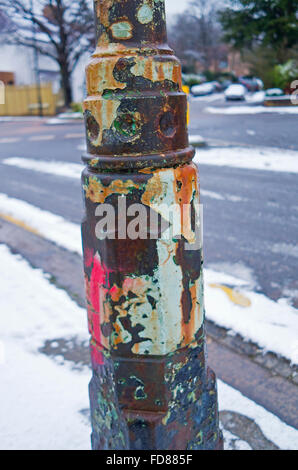Layers of weathered paint flaking from an old iron lamp post Stock Photo