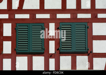 Timber framed wall with two windows with closed shutters Stock Photo