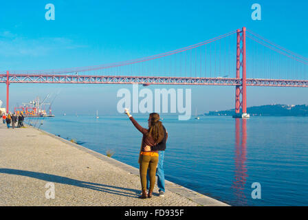 Couple taking a selfie, riverside Tagus, at Ponte 25 de Abril, Lisbon, Portugal Stock Photo
