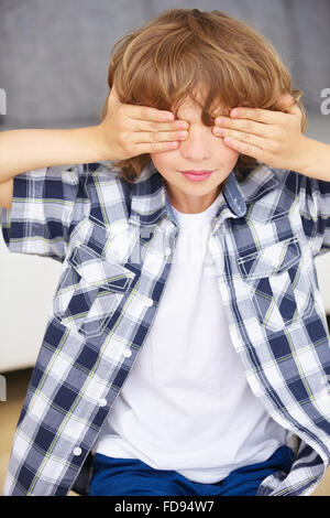 Boy covering eyes with hands Stock Photo - Alamy