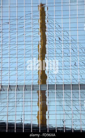 reflection of the bridge structure in the windows of a skyscraper Stock Photo