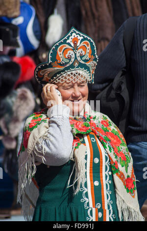 Russian singer in national dress talking on mobile phone at Izmailovsky flea market, Moscow, Russia Stock Photo