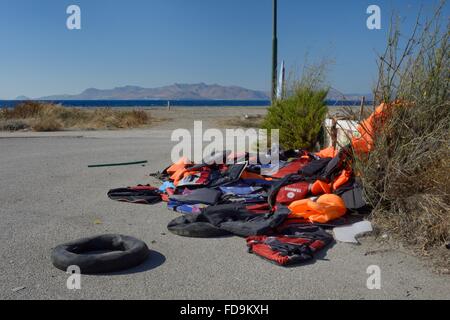 Abandoned lifejackets and rubber rings used by migrants on their journey by small boats to Greece from Turkey on the beach near Stock Photo