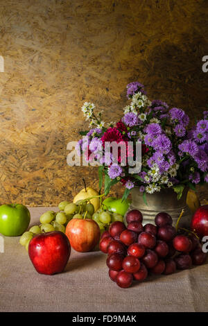 Still life with Fruits were placed together with a vase of flowers beautifully. Stock Photo