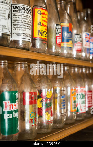 An old or vintage milk bottle collection displayed on a shelf Stock Photo