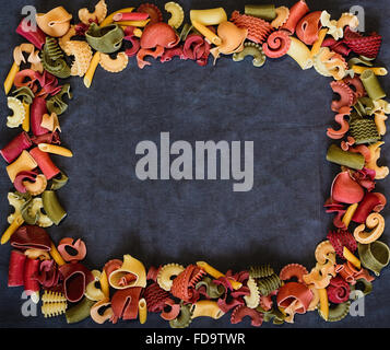 Mix of Italian pasta forming a frame on dark textile background Stock Photo