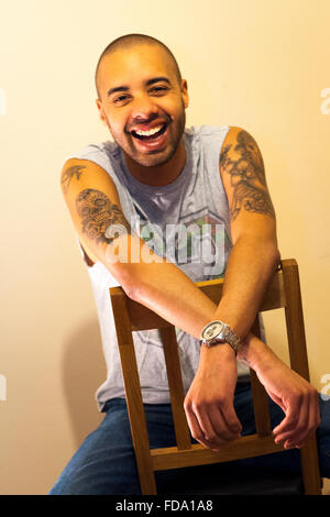 Comedian Sam Smedley laughing and sitting on a chair Stock Photo