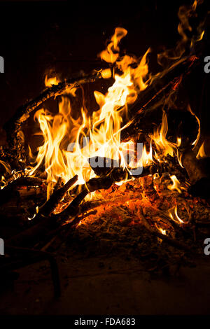 Wood fire burning in a chimney with flames burning logs and branches Stock Photo