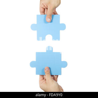 Two hands connecting puzzle pieces Stock Photo