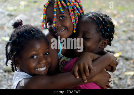 Three girls hugging each other, afro-columbian village of Playa Bonita on the river Rio Andagueda, Chocó Department, Colombia Stock Photo