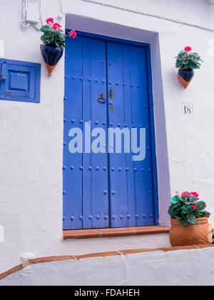 Blue Riveted Vertical Planked Door, With small single panel door to side, Frigiliana, Malaga, Andalusia, Spain. Stock Photo