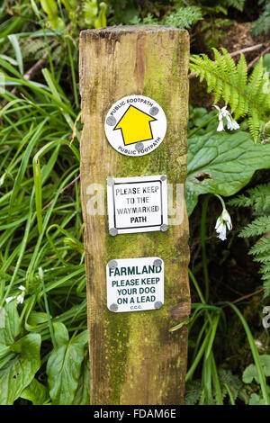 A public footpath sign saying please keep to the waymarked path and farmland please keep you dog on a lead Stock Photo