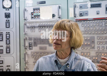 dedicated volunteer docent former Air Force member explains launch procedure to tour group in underground launch control center Stock Photo