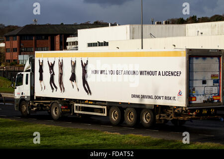 A Tesco lorry with a 'Drink Driving Advert' on the side of trailer travelling along the dual carriageway in Dundee, UK Stock Photo